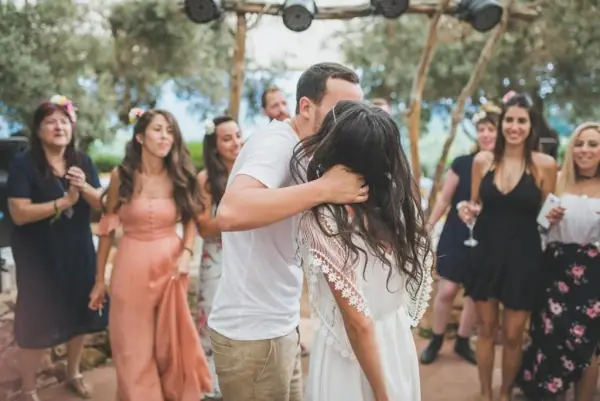 חתן וכלה בחיבוק בין אורחים רוקדים
