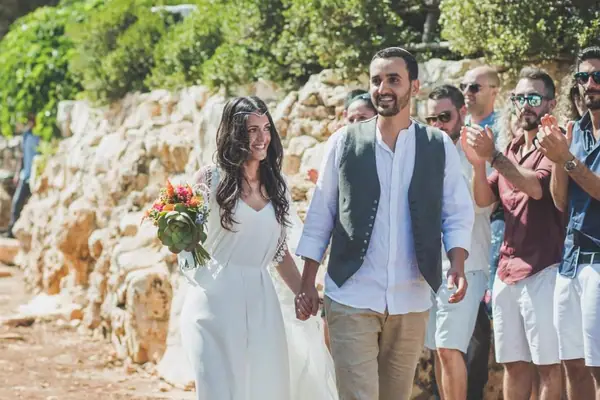 חתן וכלה הולכים יד ביד בין האורחים