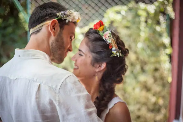 חתן וכלה עם זרי פרחים בשיער, קרובים זה לזו