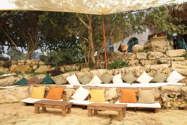 פינת לאונג' עם ספות וכריות בחצר אבן